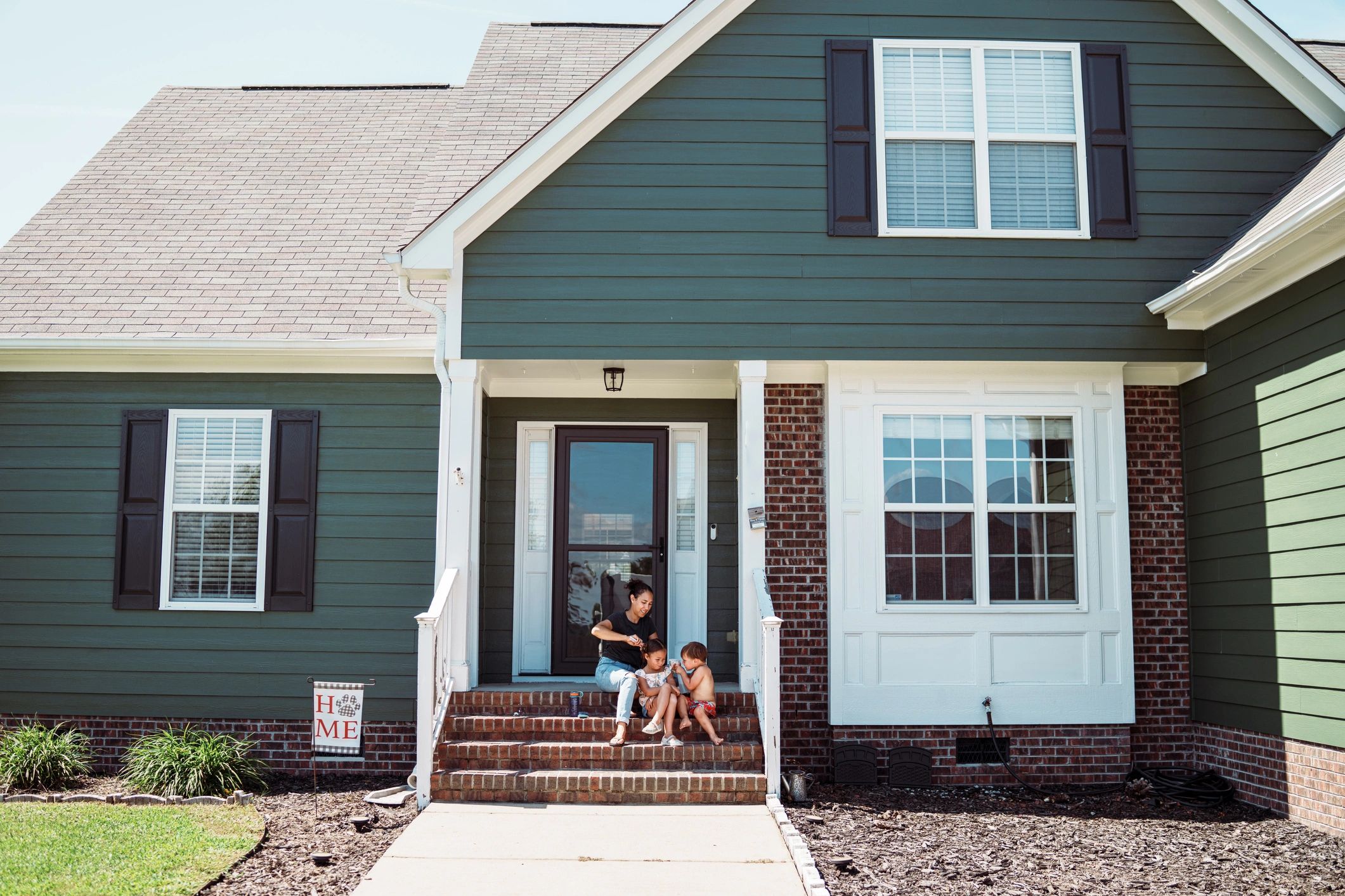 Family sitting on house steps